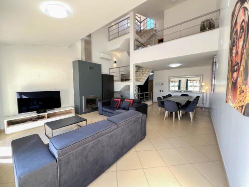 a living room with a couch and a dining room at Fantastic Villa, Private Pool, BBQ, AC and Wi-Fi in Quarteira