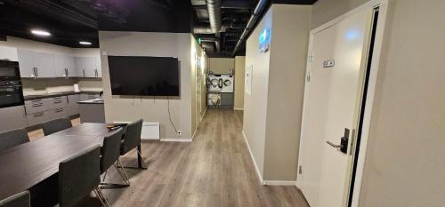 cocina con mesa y TV en la pared en Lilleby Apartment, en Trondheim