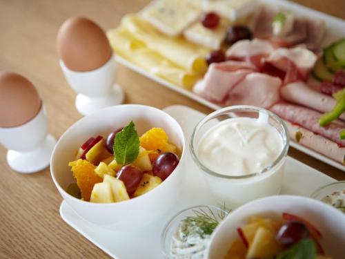 a table with a tray of food with eggs and fruit at Hotel Nepomuk in Bamberg