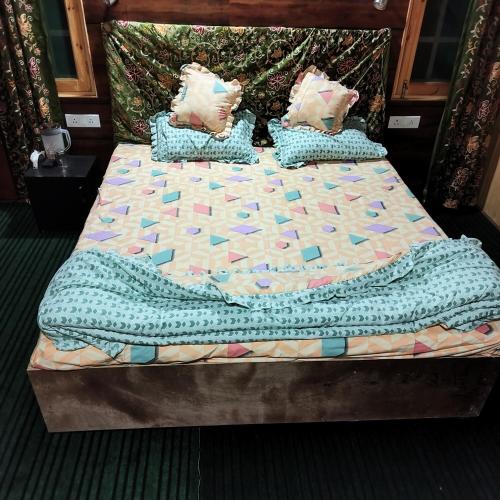 a bed with a quilt and pillows on it at Grand View Resorts Chatpal in Anantnāg