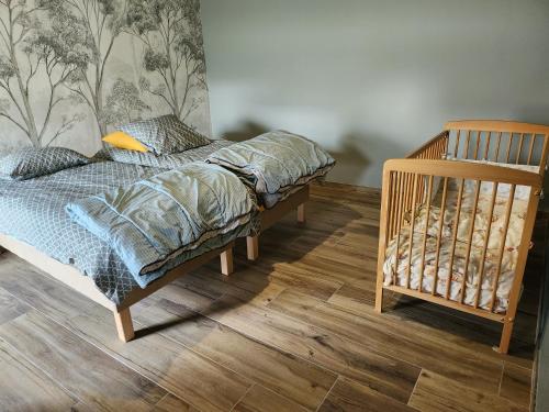 a bedroom with a bed and a crib at AU TEMPS JADIS - Gîte Atypique dans une ancienne Etable Cour privée in Gosnay