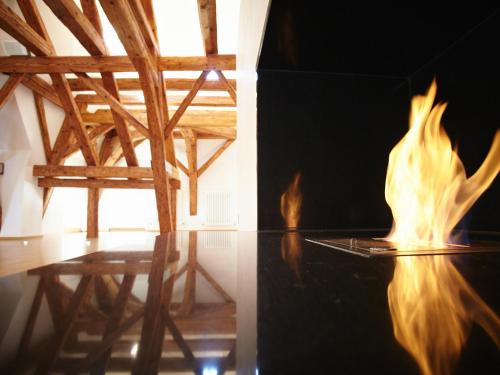 a fire in a room with a table and a chair at Hotel Nepomuk in Bamberg