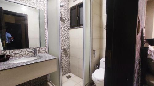 a bathroom with a sink and a toilet and a mirror at Hotel Daffodils in Rawalpindi