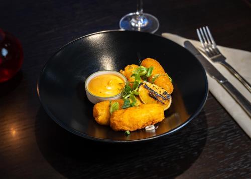 a black plate with fried food on a table at Hewitt's Restaurant & Rooms in Newport