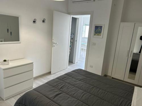 a bedroom with a bed and a dresser and a mirror at SoleeMare Barletta in Barletta