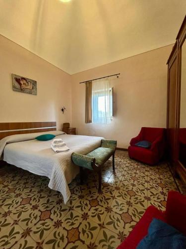 a bedroom with a large bed and a red couch at POGGIO ROSETO in Randazzo
