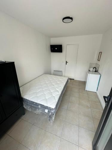 - une petite chambre avec un lit et du carrelage dans l'établissement Chez Michel, à LʼÎle-Saint-Denis