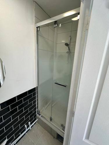 une douche avec une porte vitrée dans une salle de bain dans l'établissement Chez Michel, à LʼÎle-Saint-Denis