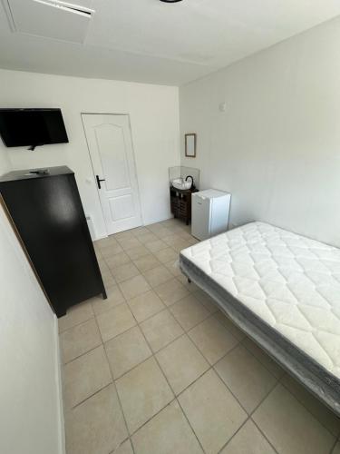 une chambre avec un lit et un sol carrelé dans l'établissement Chez Michel, à LʼÎle-Saint-Denis