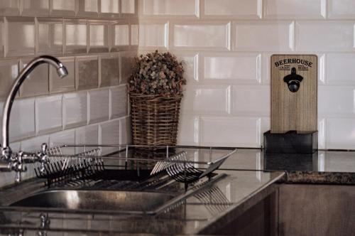 a kitchen counter with a sink and a wooden cutting board at The Only Guestroom in Kathu