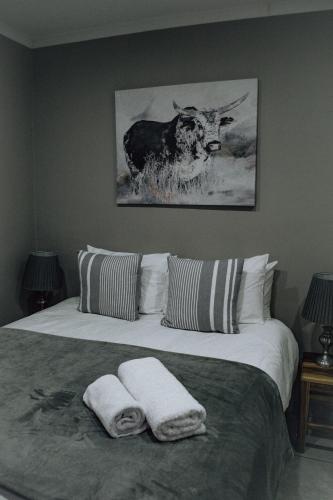 a bedroom with a bed with two towels on it at The Only Guestroom in Kathu