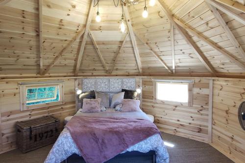 une chambre avec un lit dans une pièce en bois dans l'établissement Insolite KOTA avec SPA et demi Bt de champagne offerte, à Ruch