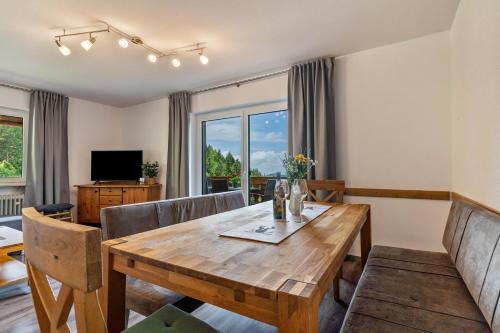 a dining room with a wooden table and chairs at Fuchsmichelhof 4 in Seebach