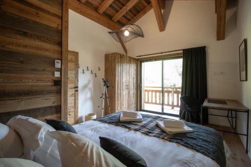ein Schlafzimmer mit großem Bett und Fenster in der Unterkunft Chalet Caly - 15pers - vue montagne in Les Gets