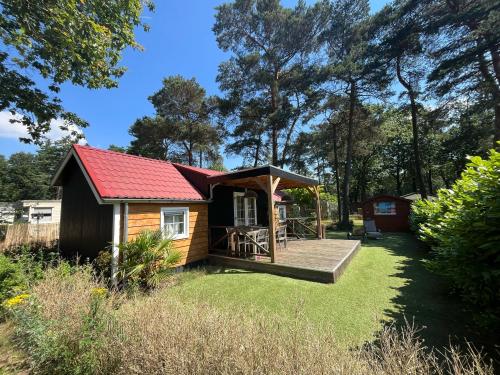 a small cabin with a deck in the grass at Bospark Wolfsven - BPW 1583 in Mierlo