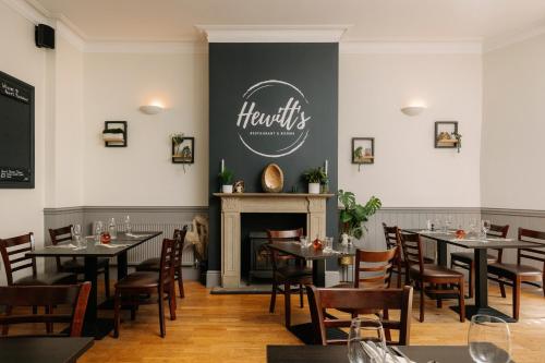 a dining room with tables and chairs and a fireplace at Hewitt's Restaurant & Rooms in Newport