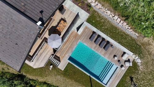 - une vue sur la piscine avec un parasol dans l'établissement Chalet Caly - 15pers - vue montagne, aux Gets
