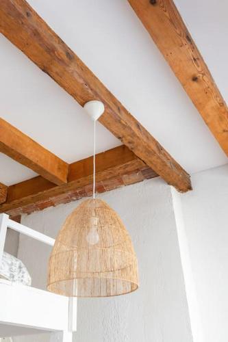 une suspension suspendue à un plafond avec des poutres en bois dans l'établissement Le Mistral - 2 min du Vieux Port sur Rue Piétonne - Les Frères de la Loc', à Marseille
