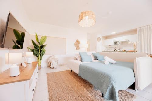 a white living room with a bed and a couch at Le Cocon de Lespinasse - Parking - Checkin Autonome in Lespinasse