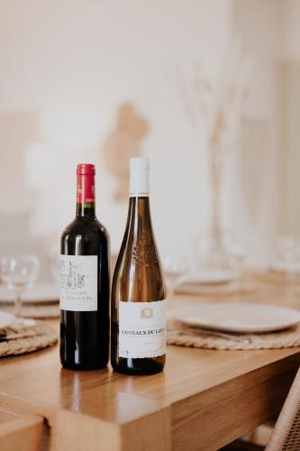 two bottles of wine sitting on a wooden table at Le Cocon de Lespinasse - Parking - Checkin Autonome in Lespinasse
