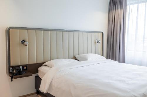 a bedroom with a large bed with white sheets at Park Inn by Radisson Reykjavik Keflavík Airport in Keflavík