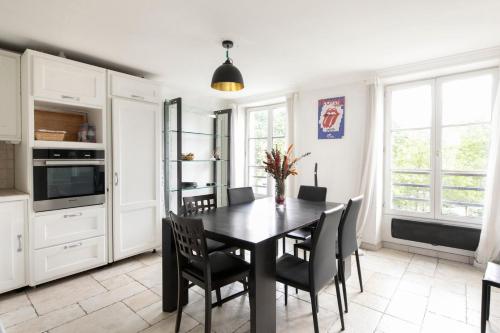 une salle à manger avec une table et des chaises dans l'établissement GuestReady - Séjour Chic au Cœur de Paris, à Paris