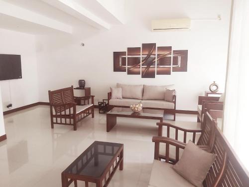 a living room with a couch and chairs at GreyLine in Gampaha