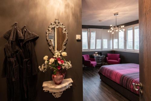 a bedroom with a bed and a mirror on the wall at Villa Braas in Breukeleveen