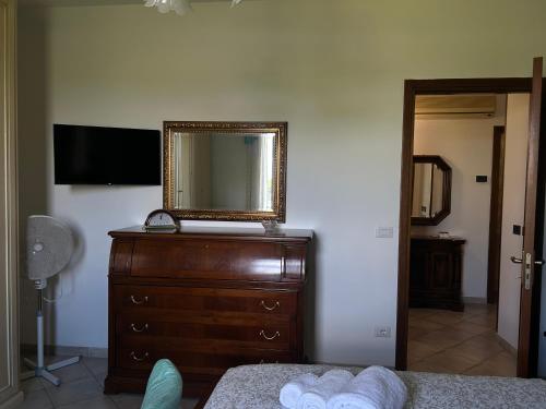 a bedroom with a dresser with a mirror on it at Dimora Toscana in Treggiaia