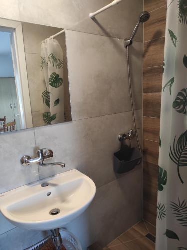 a bathroom with a sink and a mirror at Domki letniskowe "DORCIA" in Łeba