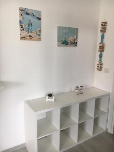a white table in a room with two pictures on the wall at SoleeMare Barletta in Barletta