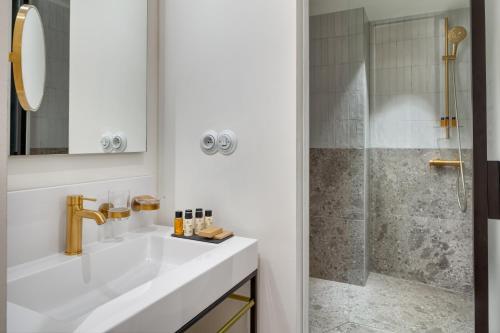 a white bathroom with a sink and a shower at Hotel BOOKQUET in Prague