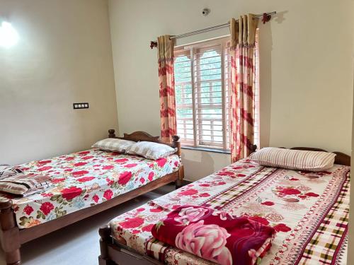 2 Betten in einem Zimmer mit Fenster in der Unterkunft Heritage Haven Retreats in Madikeri