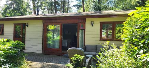 a small cottage with a porch and a patio at Huisje Vijverzicht Veluwe in Doornspijk