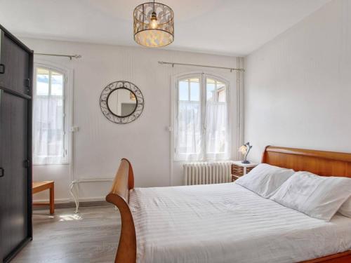 - une chambre blanche avec un lit et un lustre dans l'établissement Maison de vacances familiale près des commerces et plage à Merville Franceville - FR-1-788-10, à Merville-Franceville-Plage
