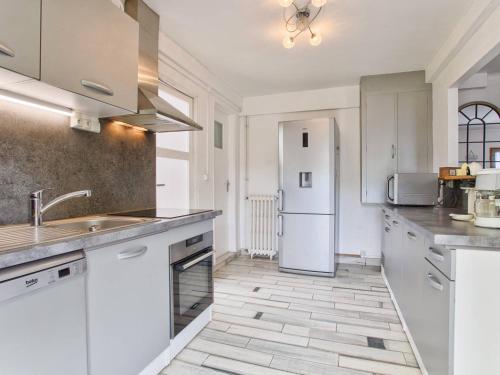 une cuisine avec des armoires blanches et un réfrigérateur blanc dans l'établissement Maison de vacances familiale près des commerces et plage à Merville Franceville - FR-1-788-10, à Merville-Franceville-Plage