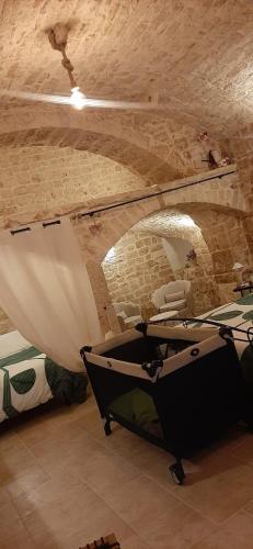 a bathroom with a toilet in a brick room at Dimora Cleó in Putignano