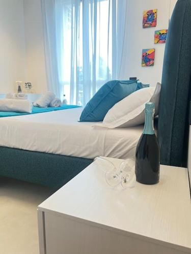 a bedroom with two beds and a bottle on a table at Il Nido Guest House in Piacenza