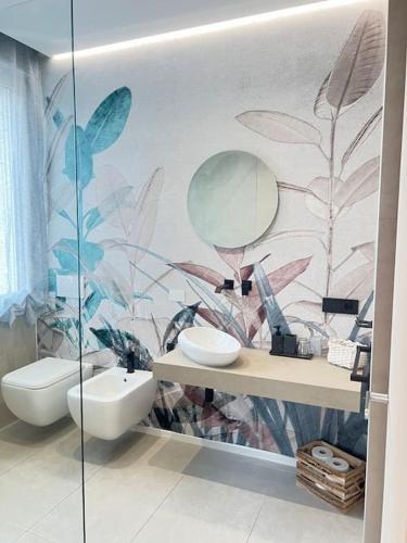 a bathroom with a toilet and a sink and a mirror at Il Nido Guest House in Piacenza