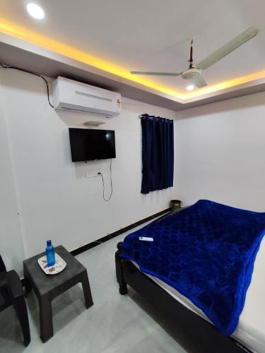 a room with a bed and a tv and a table at rest n' refresh in Visakhapatnam