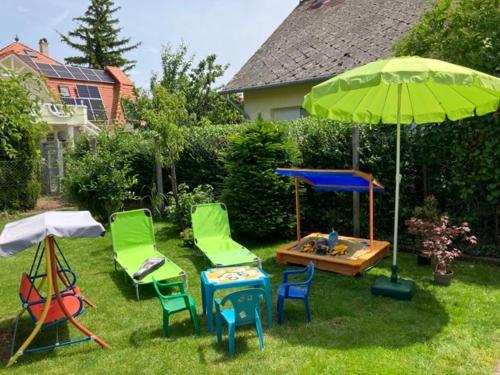 un cortile con sedie, tavolo e ombrellone di Zsuzsa Vendégháza a Balatonfüred