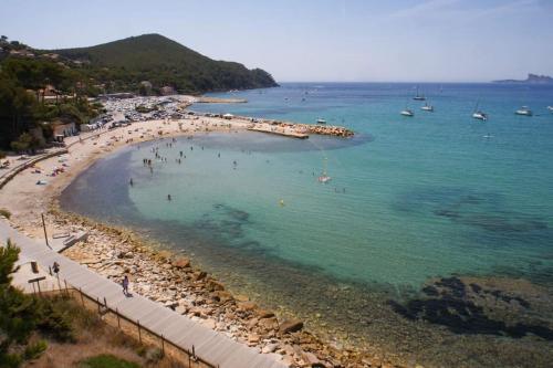 une plage avec un groupe de personnes dans l'eau dans l'établissement Porte du Var, à Saint-Cyr-sur-Mer