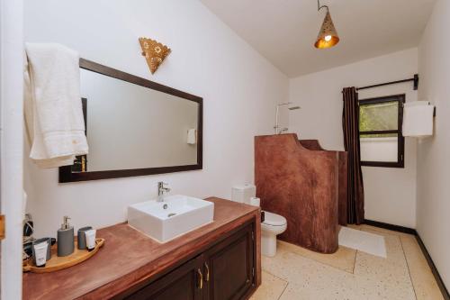 a bathroom with a sink and a mirror at Daima Villas in Jambiani