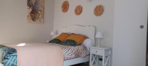 ein Schlafzimmer mit einem weißen Bett und bunten Kissen in der Unterkunft Villa Benvengudo in Villeneuve-lès-Avignon