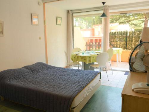 une chambre avec un lit et une table avec des chaises dans l'établissement Studio/Cabine 4 pers, Piscine, Proche Mer, Argelès-sur-Mer - FR-1-225-33, à Argelès-sur-Mer