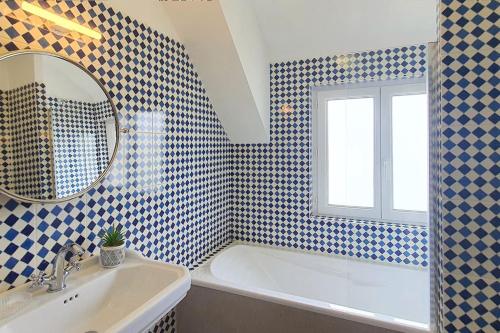 une salle de bain avec une baignoire, un lavabo et un miroir dans l'établissement Maison Le repos des pêcheurs, à Quiberon