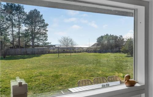 a teddy bear sitting on a window sill looking out at a field at Three-Bedroom Holiday Home In Millinge in Millinge