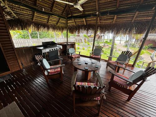 a porch with a table and chairs and a stove at Repousante Beach House in Morrumbene
