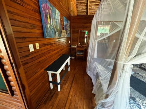 a bedroom with a bench in a wooden room at Repousante Beach House in Morrumbene