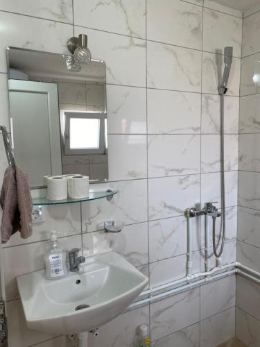 une salle de bain blanche avec un lavabo et une douche dans l'établissement Vikendica My Home, à Žabljak